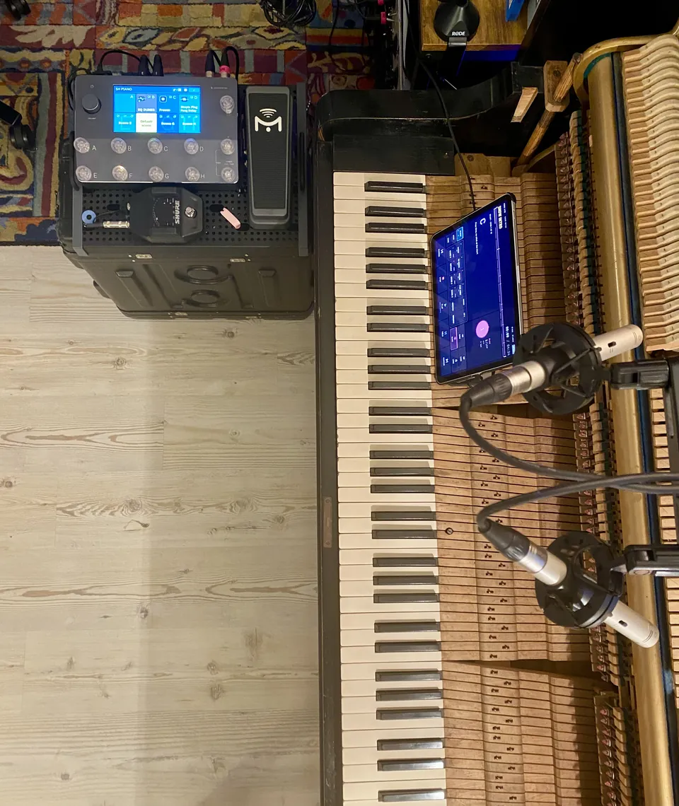 Emanuele's stage setup from above: an open upright piano, the iPad with LIVE-IN resting on the action, the Quad Cortex and an expression pedal next to it